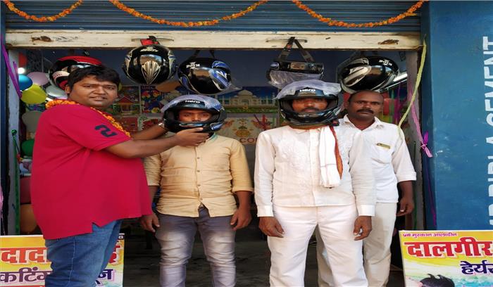 सैलून के उद्घाटन पर लोगों को हेलमेट देकर किया जागरूक