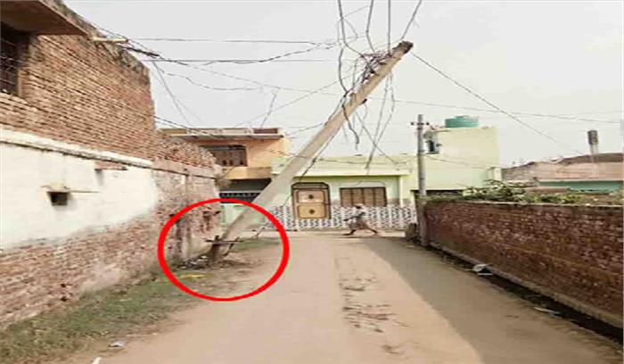क्षतिग्रस्त खम्बे के नीचे से निकलने को मजबूर ग्रामीण